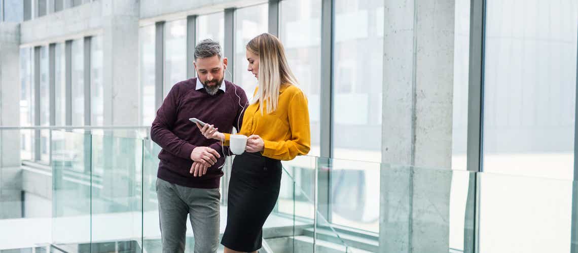 two sales professionals looking at a the status of an account on their phone, excited to see the progress they're making because of the skills they built in the prosperous account strategy training program