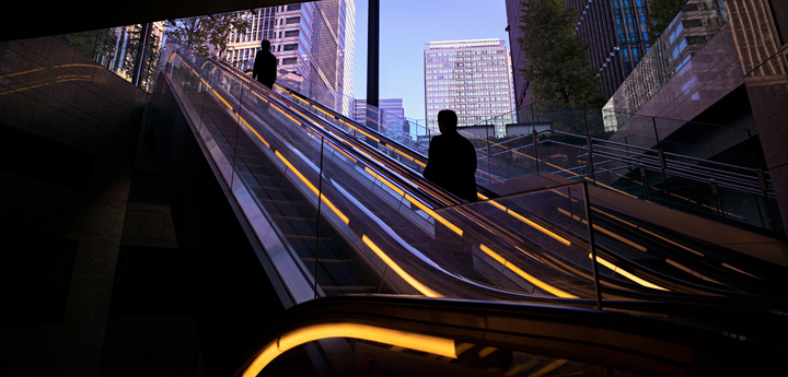Person on outdoor escalator in dark corridor