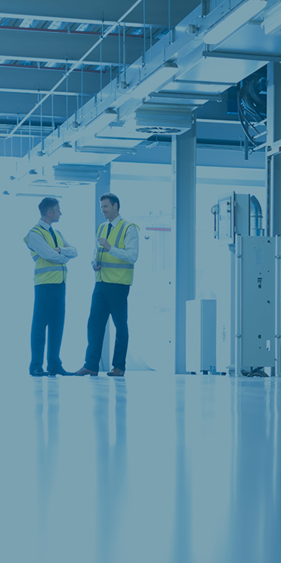 two men in the far ground among industrial machinery